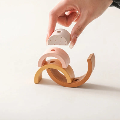 Woman's hand interacting with the Montessori Wooden Baby Dragging Car by placing a rainbow arc on the Dragging Car's back.